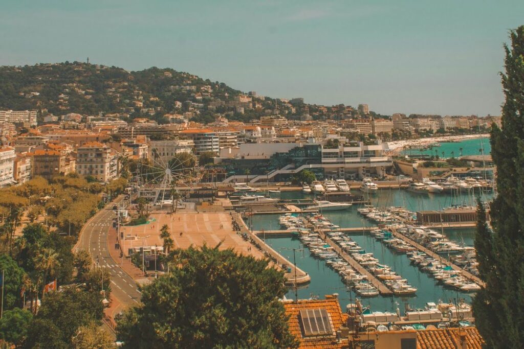 A coastal town with a large marina of moored boats and a hillside backdrop.