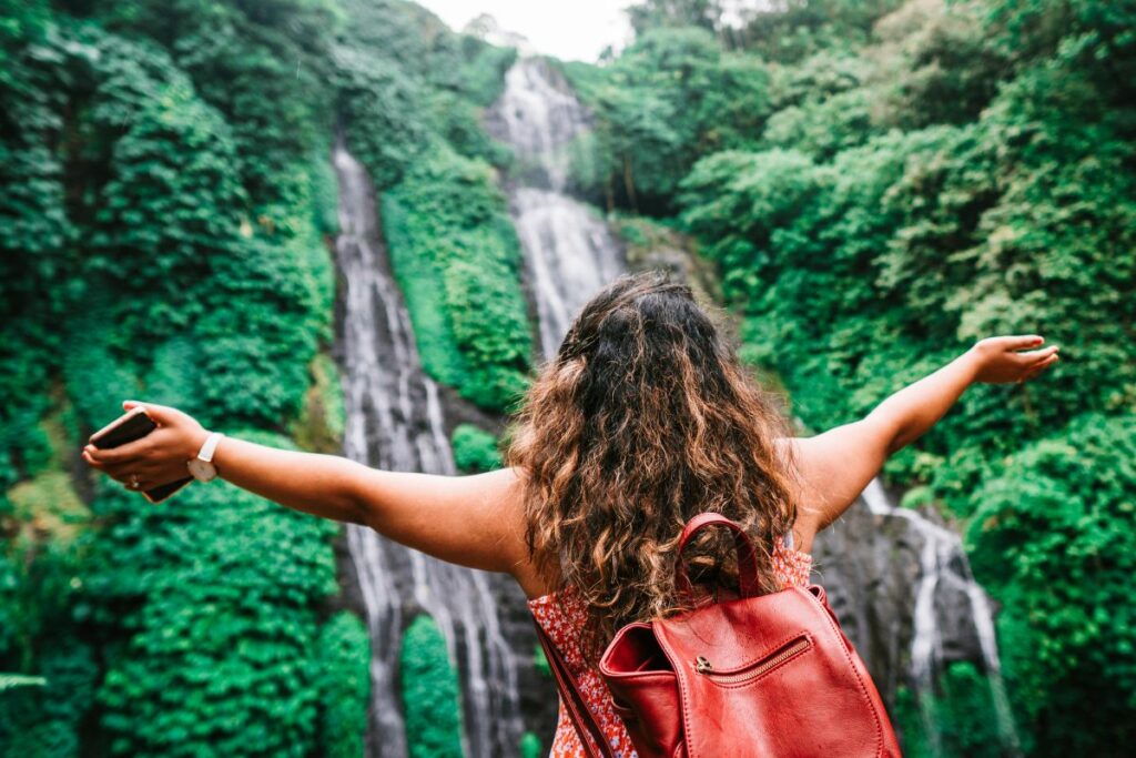Femme qui célèbre devant une cascade