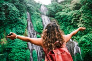 Femme qui célèbre devant une cascade