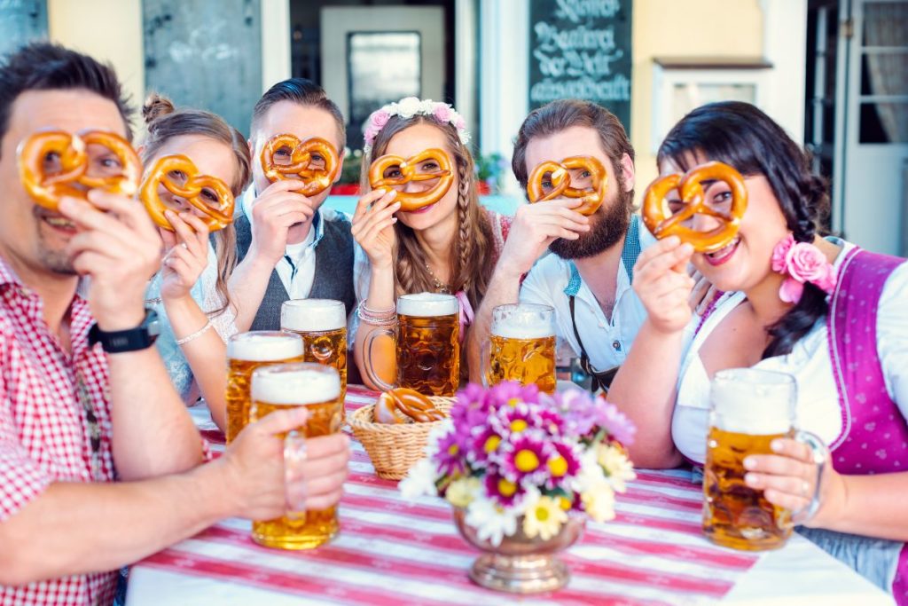 Amis buvant une bière et mangeant un bretzel en Allemagne