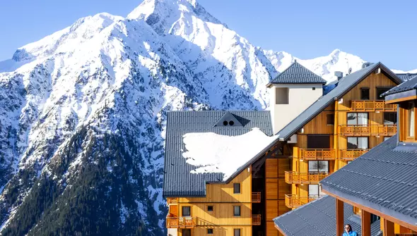 Chalet en bois au pied des montagnes enneigées pour un séjour au ski via le programme Départ 18:25 de l'ANCV