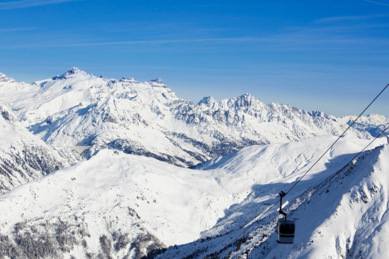 Panorama magnifique des sommets enneigés et pistes de ski en Auvergne-Rhône-Alpes.